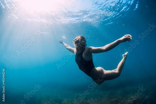 Young woman freediver posing underwater in sea. Freediving and lady