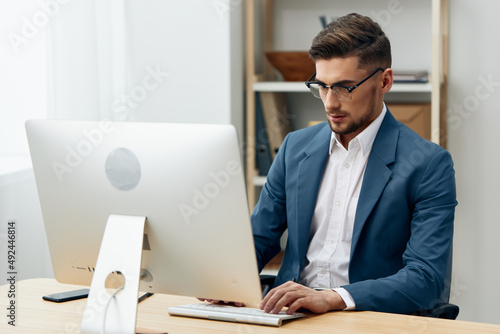 a man in a suit sitting at the computer work boss technologies