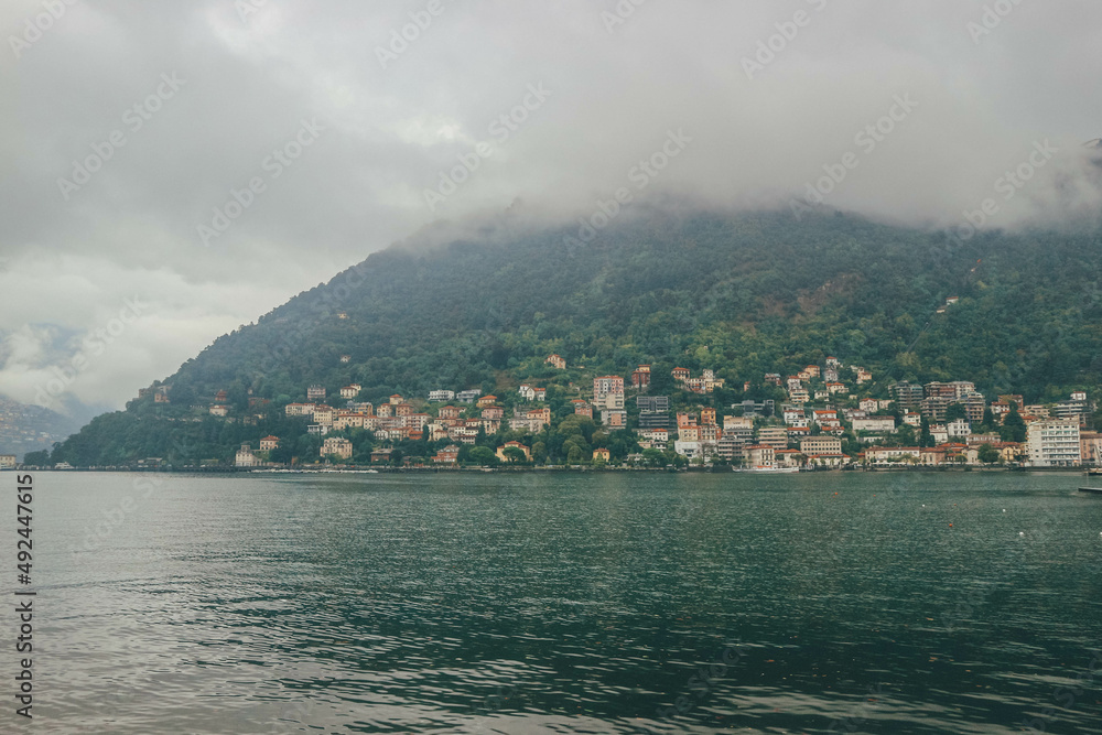 Houses view at bottom of mountain in cloudy day on Como Lake, Italy