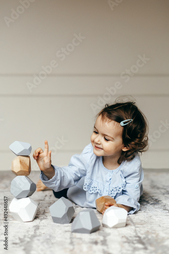 Child playing with wooden stones Tumi Ishi