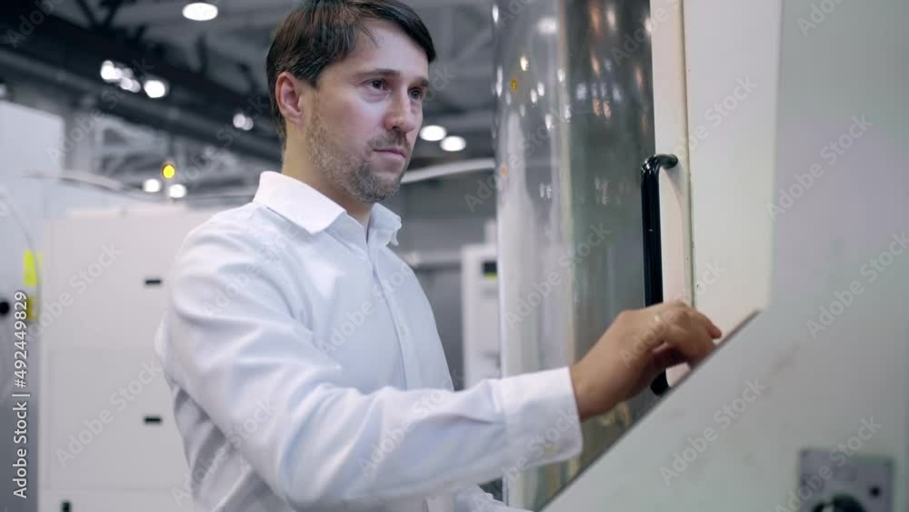 An engineer at an industrial plant. A worker controls the operation of a CNC milling machine. Tablet computer in hand. Drill manufacturing plant. An engineer at an industrial plant. A worker controls the operation of a CNC milling machine. Tablet computer in hand. Drill manufacturing plant.