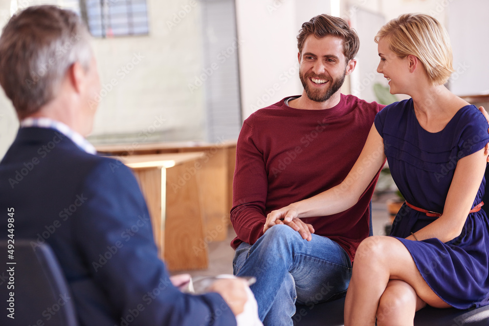 Their investments are growing. Young couple discussing investment plans with a financial advisor. Their investments are growing. Young couple discussing investment plans with a financial advisor.