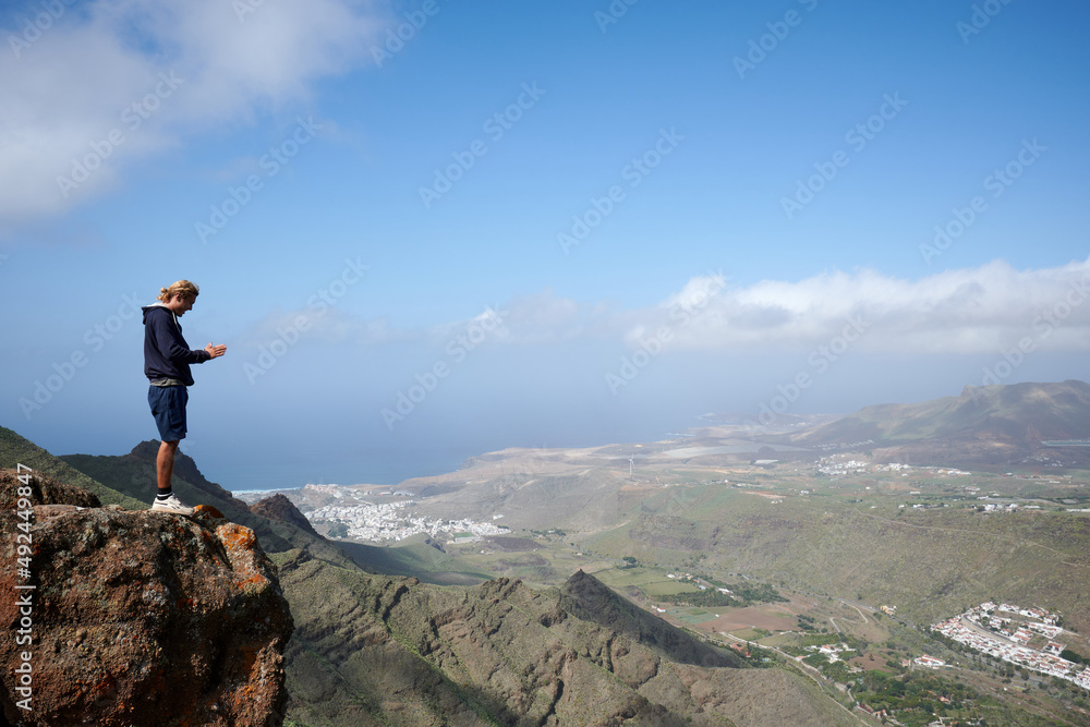 A young man admiring the beautiful views in the mountains in Gran Canaria A young man admiring the beautiful views in the mountains in Gran Canaria