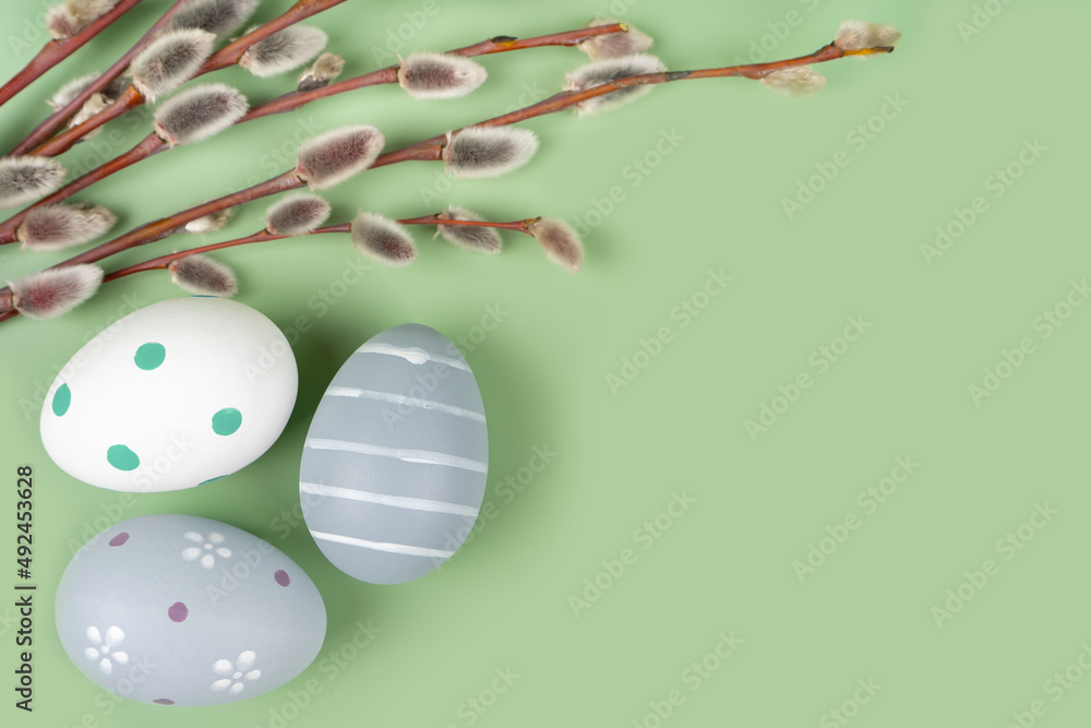 Willow branches and colorful easter eggs on a light green background. Happy easter flat lay, mockup with copy space for text Willow branches and colorful easter eggs on a light green background. Happy easter flat lay, mockup with copy space for text