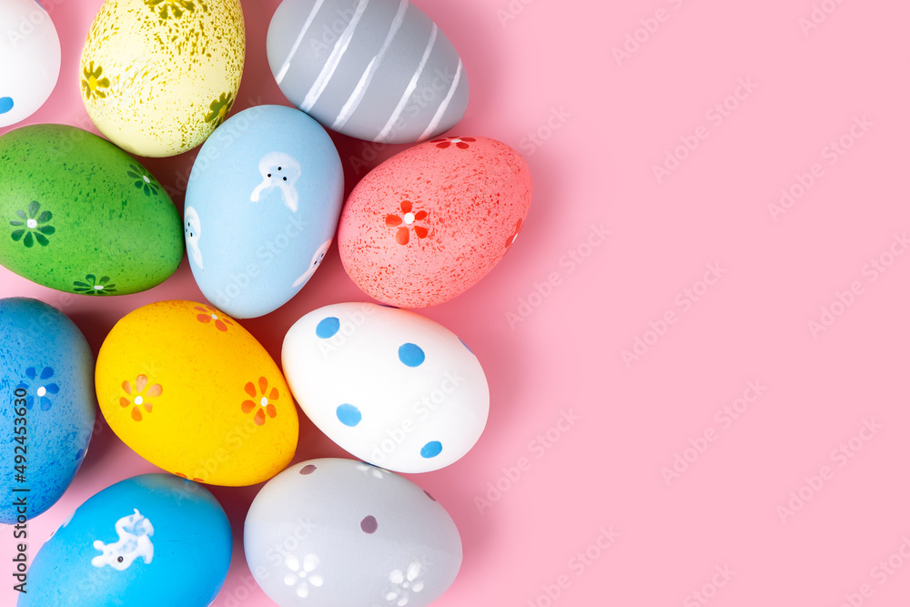 Colorful easter eggs on pink background. Easter mockup, top view, flat lay with copy space