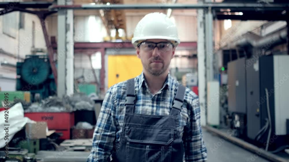 Engineer in hard hat is moving through a heavy industry factory with a tablet computer. Slow-Motion. Engineer in hard hat is moving through a heavy industry factory with a tablet computer. Slow-Motion.