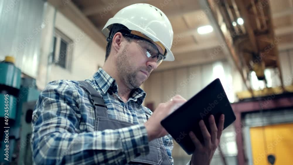 Engineer Is Using Tablet Pc In Factory. Slow-Motion. Engineer Is Using Tablet Pc In Factory. Slow-Motion.