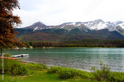 teal water of Maligne Lake in late summer with mountains in background