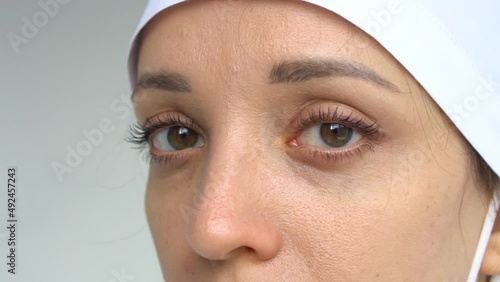 Female doctor is putting off protective blue gloves isolated on white background after some medical manipulations, vaccination.