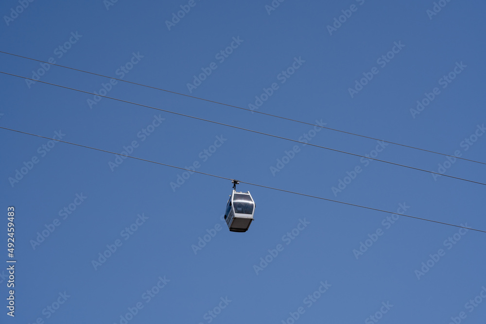 a small gray cable car with diagonal blue skies