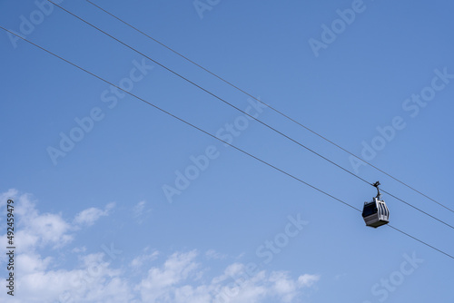 a small gray cable car with diagonal blue skies