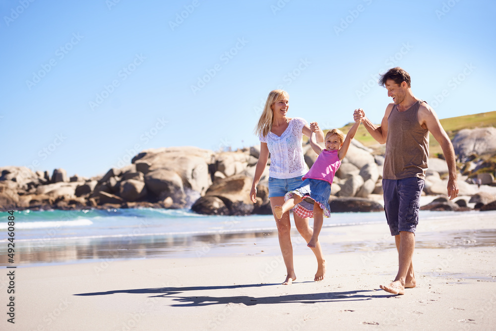 Enjoying the beach together. Shot of a happy young family taking a walk on the beach.