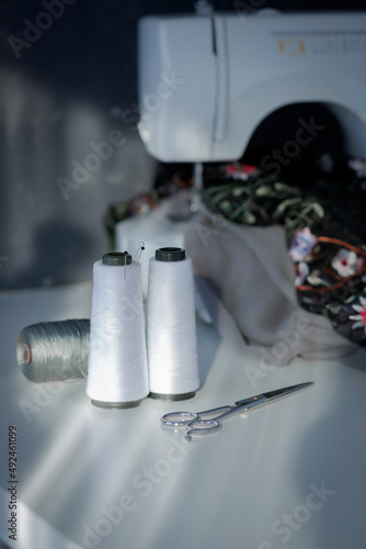 Wallpaper Mural Reels of white threads and sewing accessories. Sewing accessories on white table with natural light from the window Torontodigital.ca