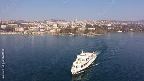 Aerial drone footage a cruise ship that leaves the Ouchy harbor in Lausanne city on the lake Geneva in Switzerland. Shot with a forward motion