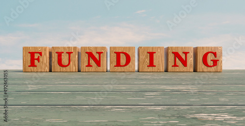Funding. Wood dice with red letter on old weathered wooden planks. 3D illustration
