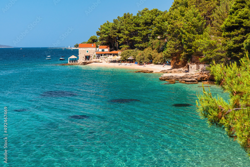 Obraz premium Beautiful view of Adriatic sea with a small restaurant on the pebble beach, Bol, Brac island, Croatia