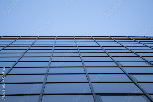 Wall of windows of modern building office skyscraper with perspective background sky