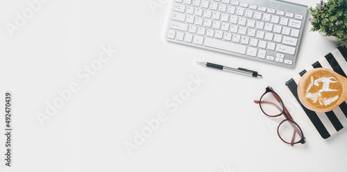 Office desk with keyboard computer, Pen, notebook, Cup of coffee, eyeglass on white background, Top view with copy space, Mock up....