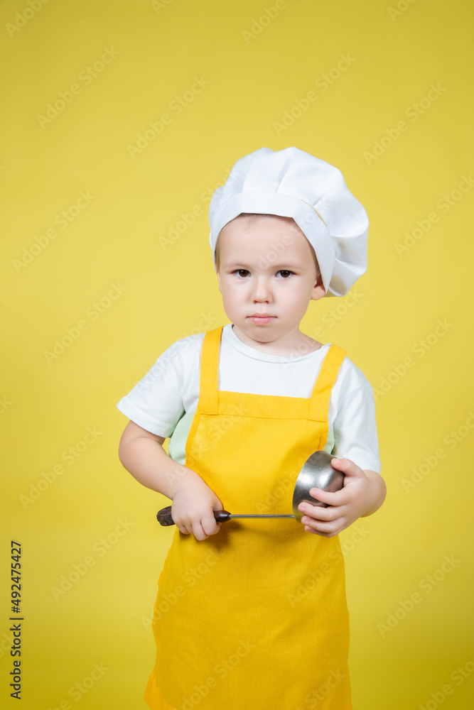 Little caucasian Boy playing chef, boy in apron and chef's hat posing Little caucasian Boy playing chef, boy in apron and chef's hat posing
