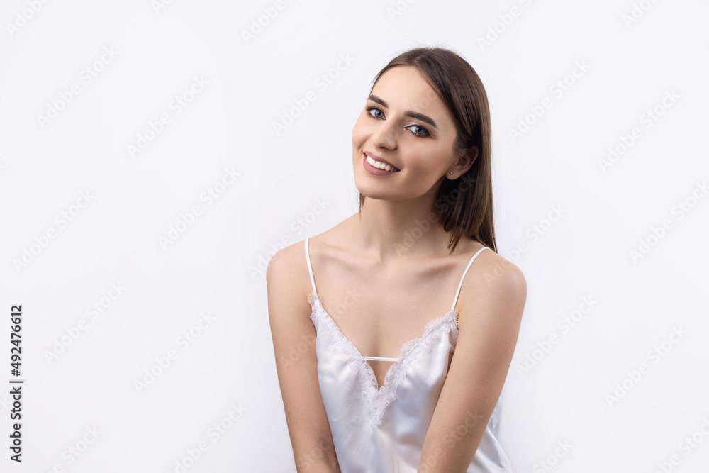 Beautiful smiling woman with clean skin, natural make-up and white teeth on a gray background