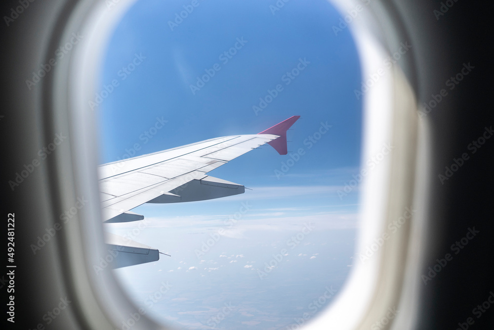 looking through airplane window during the flight, cloudscape view looking through airplane window during the flight, cloudscape view