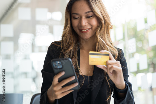 Happy smile young adult asian woman consumer using creadit card and smartphone. photo