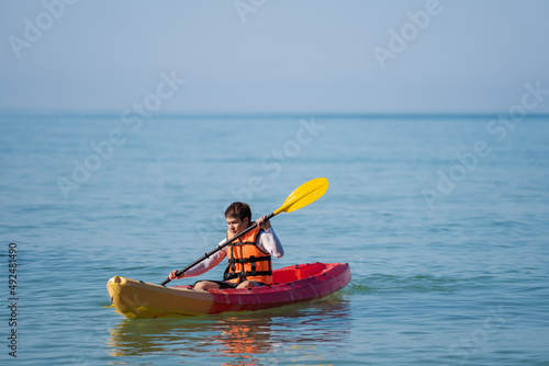 man in life jacket paddling a kayak boat in sea © geargodz