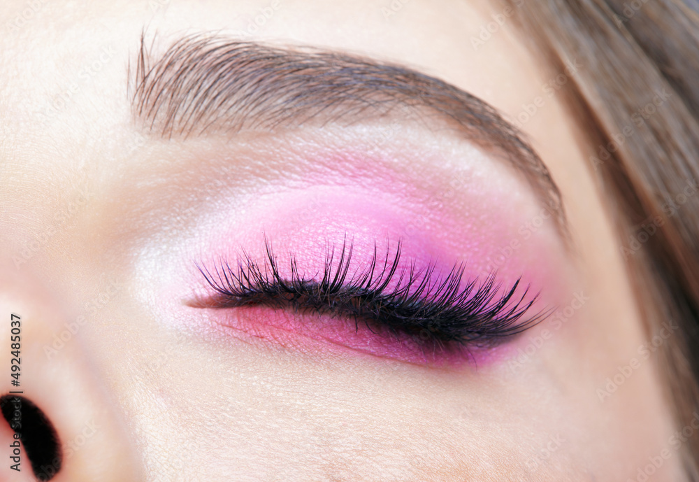 Obraz premium Closeup macro shot of closed human female eye. Girl with perfect skin and pink eyes shadows