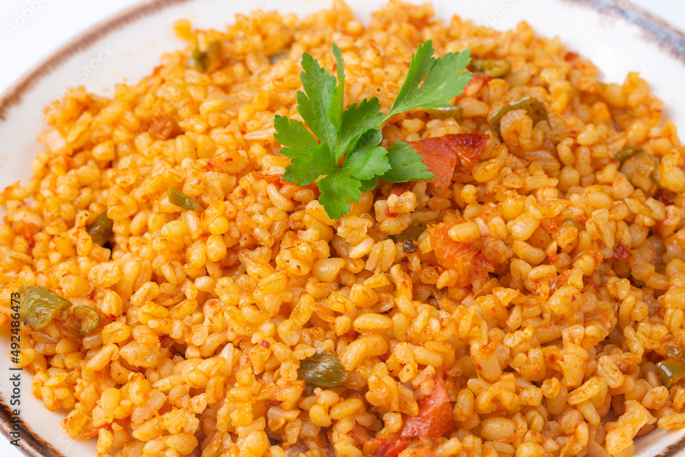 Traditional turkish bulgur pilaf with tomato sause in plate (Turkish name; meyhane pilavi) Traditional turkish bulgur pilaf with tomato sause in plate (Turkish name; meyhane pilavi)