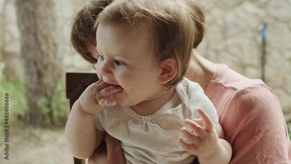 Video of a senior woman holding her granddaughter sitting outdoor. Family care. Video of a senior woman holding her granddaughter sitting outdoor. Family care.