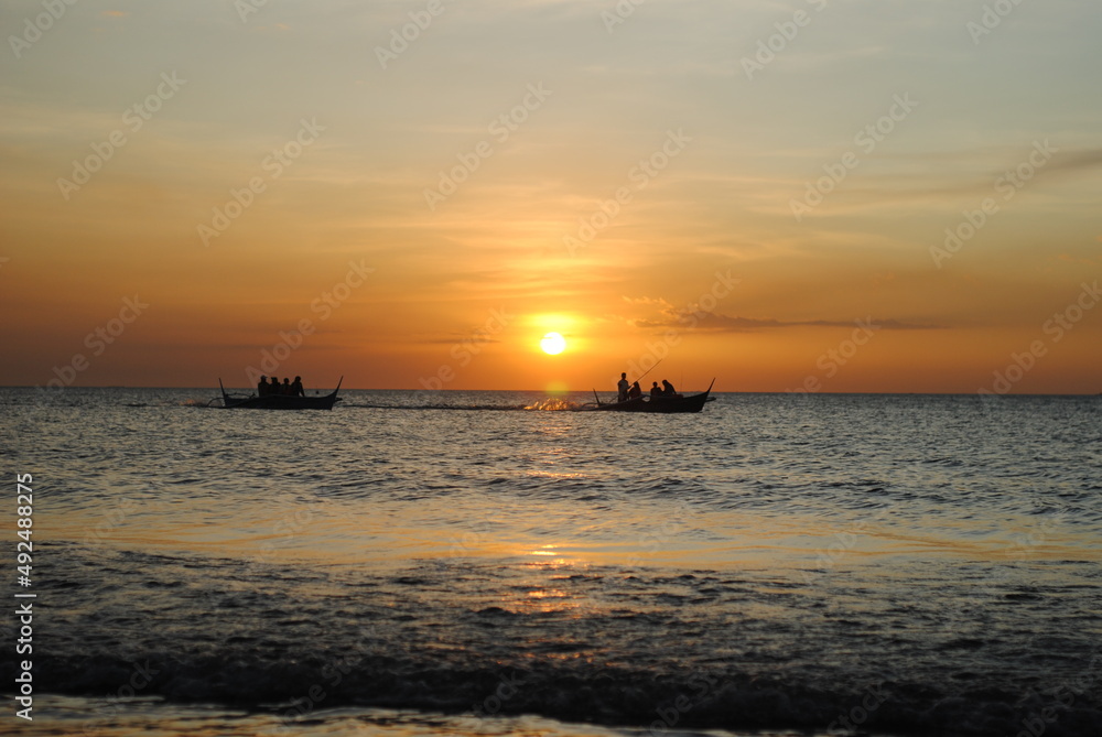 sailing boats silhouette in the ocean at sunset