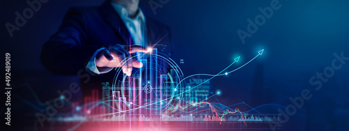 Obraz na płótnie Businessman touch growth graph and progress of business and analyzing financial and investment data ,business planning and strategy on city background