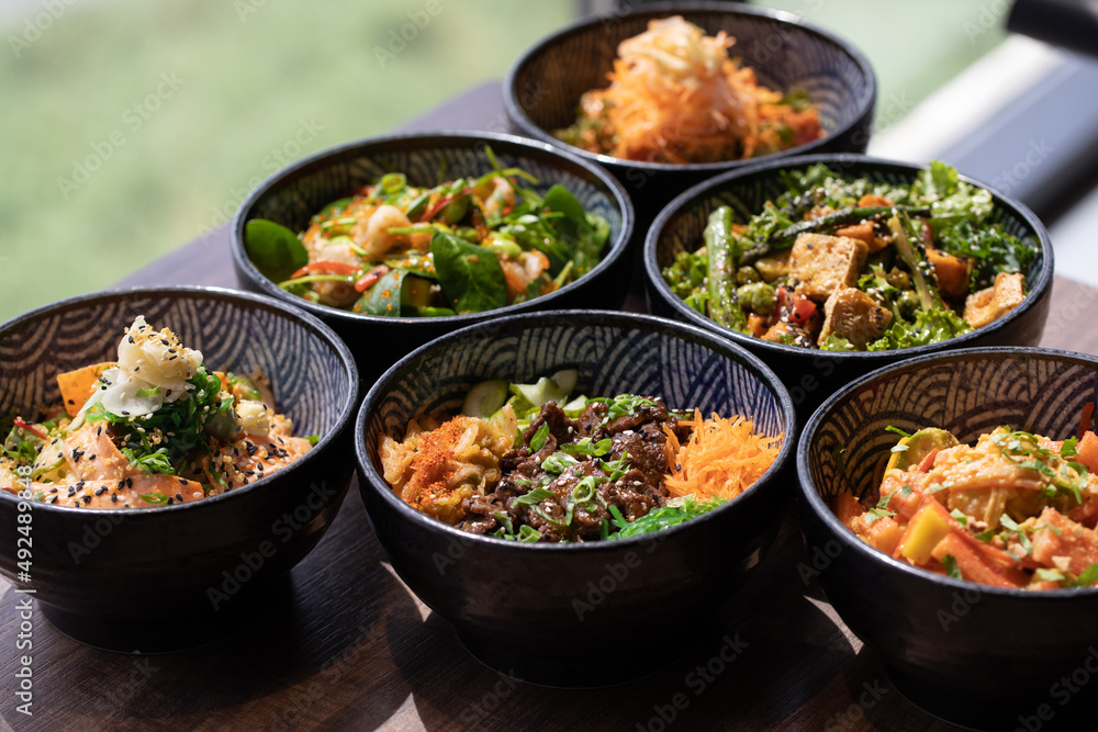 Poke bowls and other gourmet foods, with drinks and sushi on the table, Poke bowls and other gourmet foods, with drinks and sushi on the table,