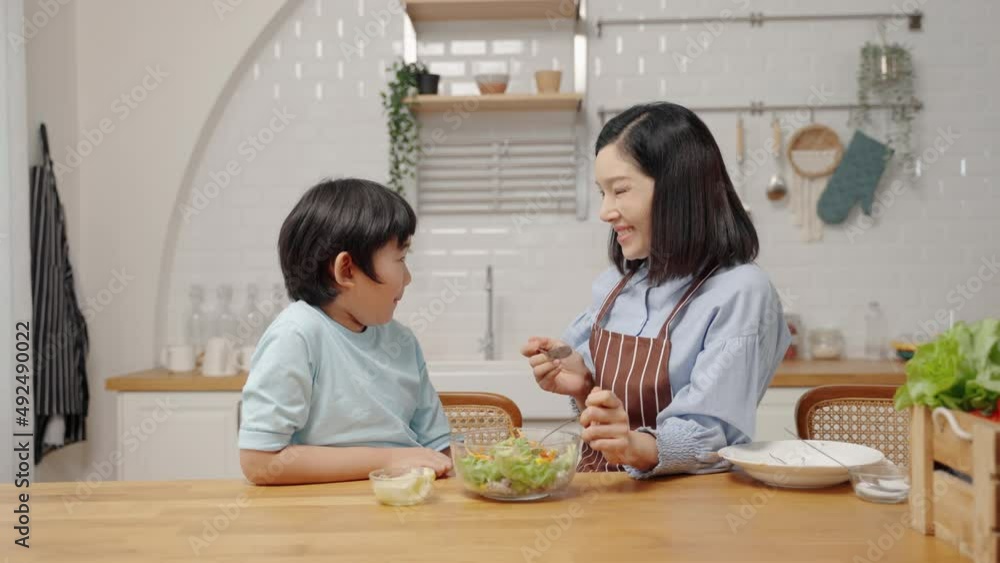 Asian happy family cooking in kitchen room at house.Mother is feeding her son salad to learn how to eat vegetables for health benefits.Family relationship
Asian happy family cooking in kitchen room at house.Mother is feeding her son salad to learn how to eat vegetables for health benefits.Family relationship