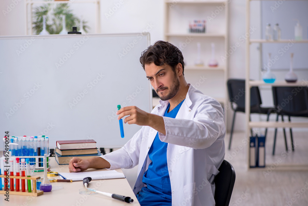Young male chemist working at the lab Young male chemist working at the lab