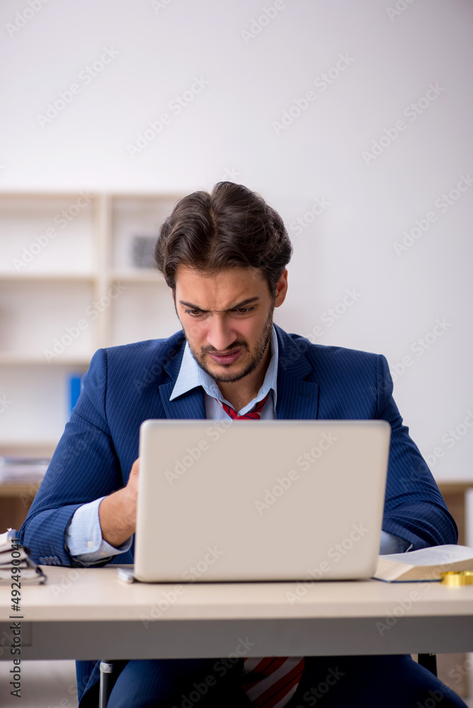 Young male employee working in the office Young male employee working in the office