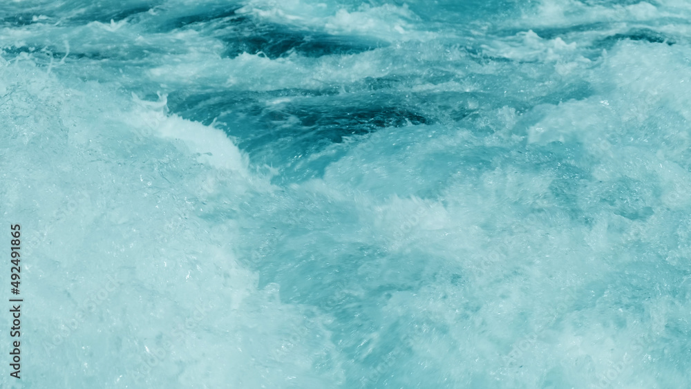 Close-up, strong splash of sea turquoise water from fast sailing motor boat. Powerful white foam waves rise, break into splashes. Huge stream of crystal clear green tide water in ocean Close-up, strong splash of sea turquoise water from fast sailing motor boat. Powerful white foam waves rise, break into splashes. Huge stream of crystal clear green tide water in ocean