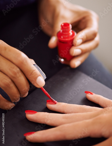 Ravishingly red nails. Closeup of fingernails being painted red.