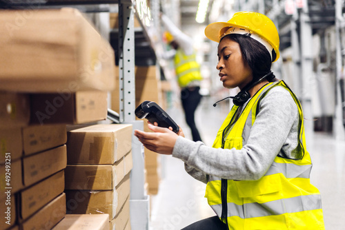 Portrait of african american engineer woman scanning package with barcode scanner check goods in transportation and distribution in warehouse.logistic Industrial and business export photo