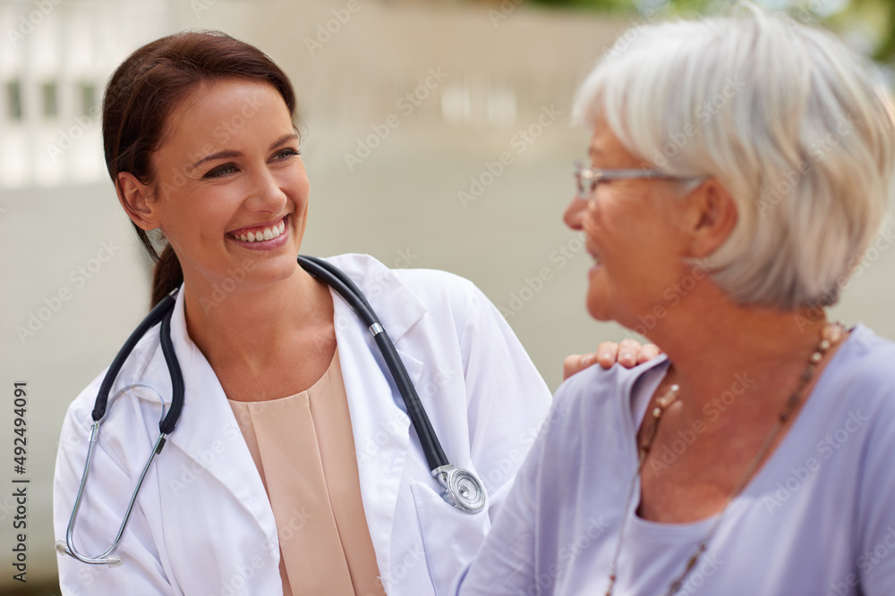 Kind and caring professional. Shot of a smiling doctor conversing with a senior patient. Kind and caring professional. Shot of a smiling doctor conversing with a senior patient.