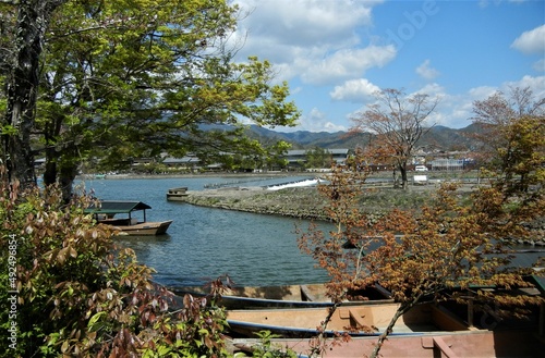 A view of Oi-gawa (Hozu-gawa) River flowing through Arashiyama and autumn leaves and excursion boats in Kyoto City in Japan日本の京都市嵐山を流れる大堰川と紅葉と遊覧ボートの一風景