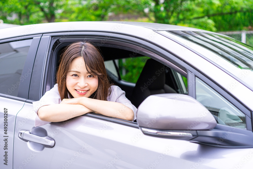 運転席から顔を出す若い女性 運転席から顔を出す若い女性