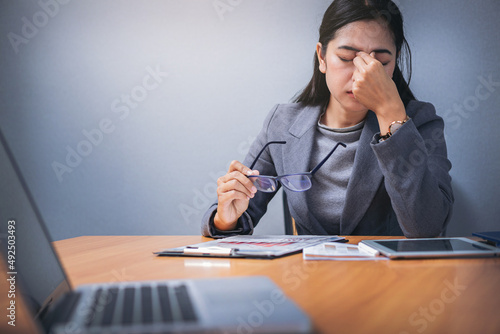 Tired businesswoman with eye pain during working in office overwork.