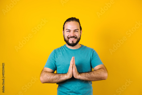 Young latin man practicing breathing or meditating or yoga class on yellow background in Mexico Latin America 