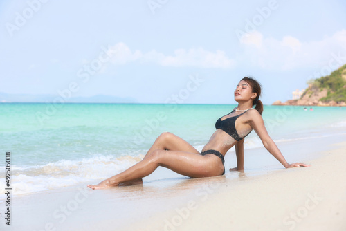 Portrait Sexy woman on the beach at island tanned woman with bikini suntan relaxing on tropical beach, summer vacation sunbathing