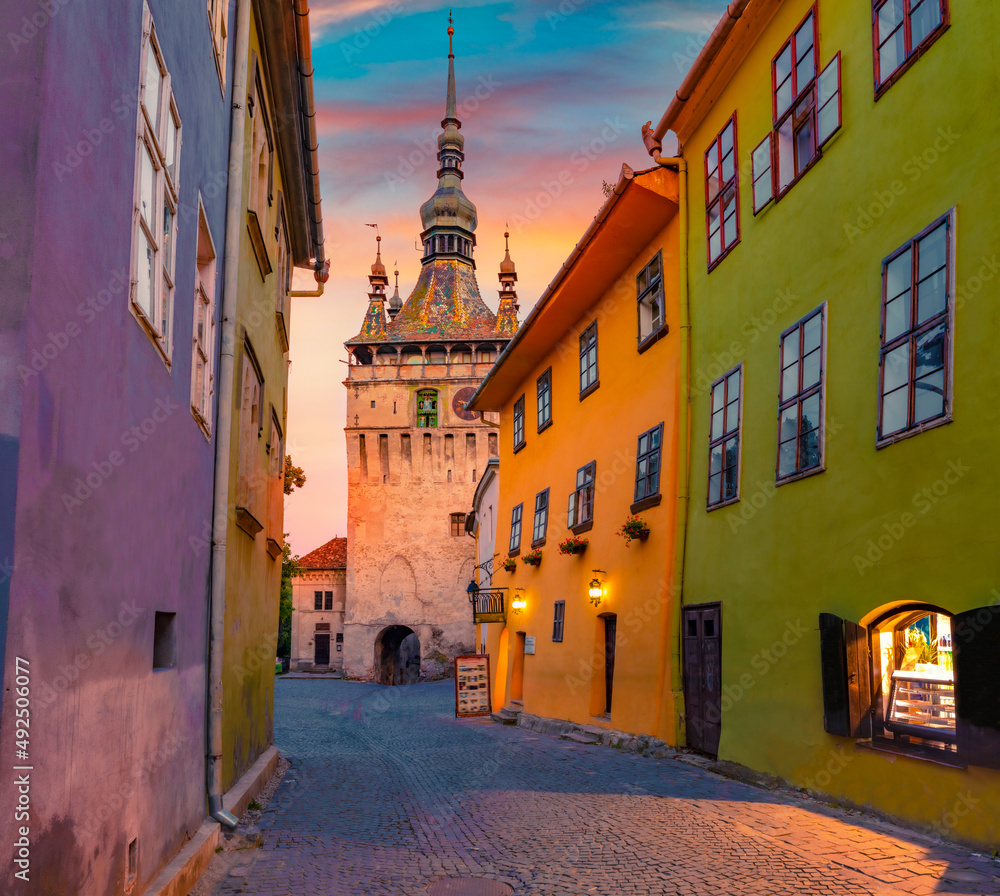 Fototapeta premium Impressive evening view of famous medieval fortified city and the Clock Tower built by Saxons. Superb summer cityscape of Sighisoara, Transylvania, Romania, Europe. Traveling concept background.