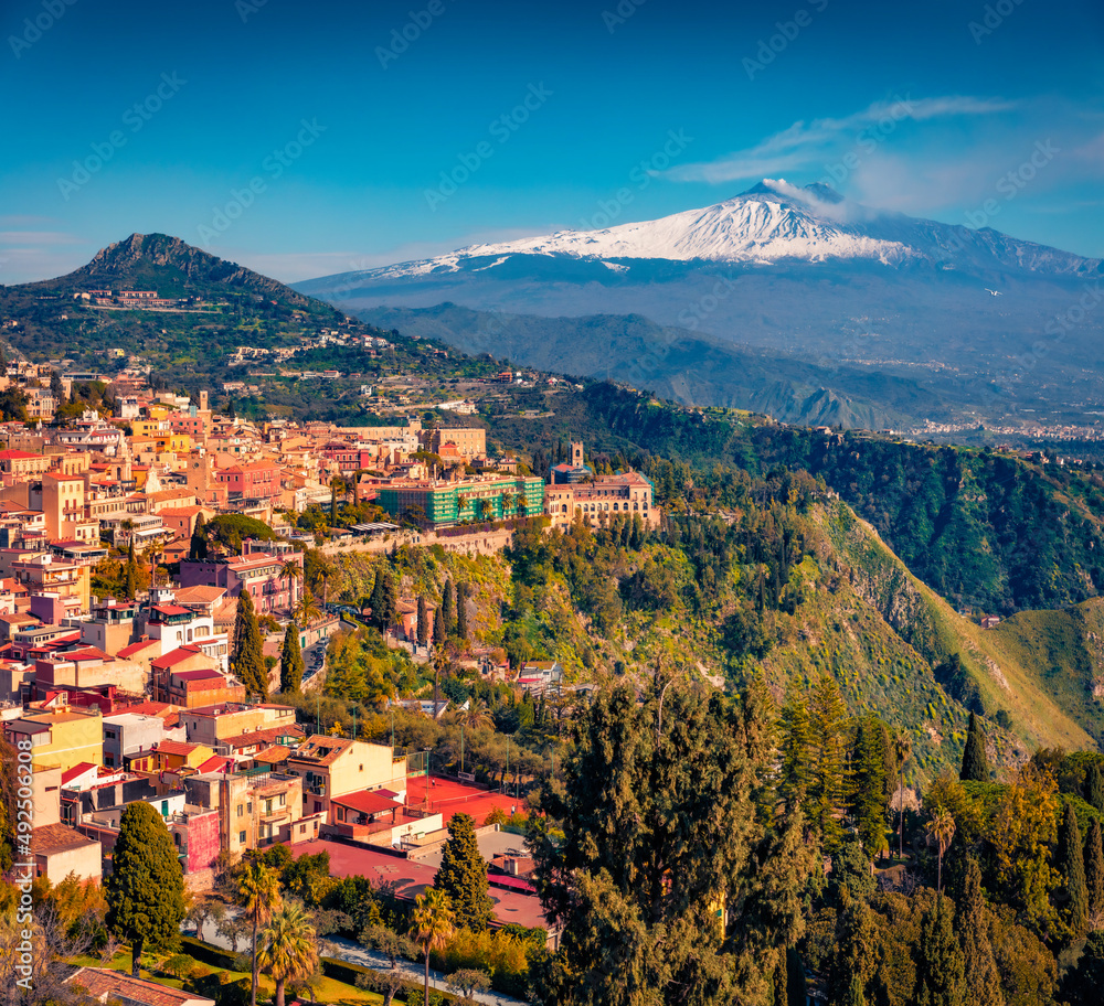 Sunny summer view from flying drone of Taormina town and Etna volcano on background. Picturesque morning  view of Sicily, Italy, Europe. Traveling concept background.