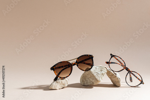 Sunglasses and glasses sale concept. Trendy sunglasses on beige background. Trendy Fashion summer accessories. Copy space. Summer sale. Optic store discount poster. Minimalism photo