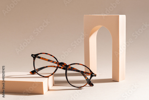 Trendy Eyeglass frame on beige Background, trendy Still Life Style. Tortoiseshell frame glasses. Optic store advertisement background. Copy space. Minimalism. Glasses sale concept. Eyeweare photo