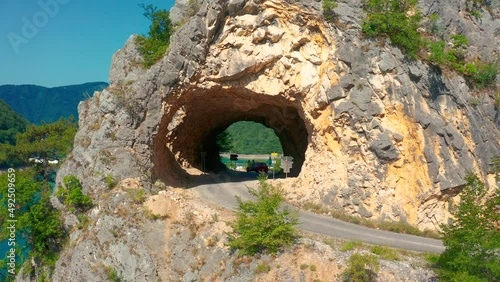 Tourists stand in the tunnel at Piva Lake in national park Dormitor of Montenegro at summer. photo